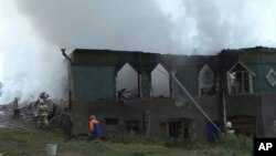 Para petugas berupaya memadamkan api di rumah sakit jiwa di desa Luka, wilayah Novgorod, Rusia, Jumat pagi (13/9).