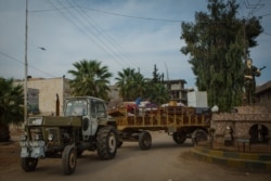 Families gather their belongings and flee, in Darbasiyah, Syria, Oct. 22, 2019. (VOA/Yan Boechat)