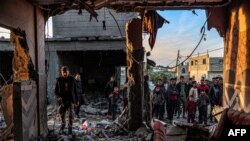 Njerëzit inspektojnë rrënojat e një ndërtese të bombarduar nga Izraeli në qytetin jugor Rafah, në Rripin e Gazës më 11 shkurt, 2024/AFP