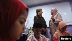 Kepala Komisi Tinggi HAM PBB, Michelle Bachelet (kiri belakang) berbincang dengan seorang guru saat mengunjungi sekolah Rohingya di Kajang, Malaysia, 4 Oktober 2019. (Foto: Reuters) 