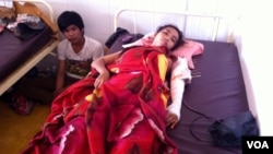 ហៀរ រ៉ាឌី អាយុ​២០​ឆ្នាំ​ជា​កម្មការី​រោងចក្រ​កាណាឌីយ៉ា សម្រាក​ព្យាបាល​នៅ​មន្ទីរពេទ្យ​កាល់ម៉ែត​ក្រុង​ភ្នំពេញ។ ​សមត្ថកិច្ច​បាញ់​ចូល​តាម​ចន្លោះ​ទ្វារចំ​ទ្រូង​និងដើម​ដៃ​ខាង​ឆ្វេង​ ខណៈពេល​នាង​បង្ហើប​ទ្វារ​មើល​ការ​បាញ់ប្រហារ​លើ​ហ្វូង​បាតុករ ដែល​ស្ថិត​នៅចម្ងាយ​ប្រមាណ​៥០​ម៉ែត្រ​ពី​បន្ទប់​ជួល​របស់​នាង។ (ឃួន​ ធារ៉ា/VOA)