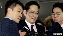 Jay Y. Lee (center) vice chairman of Samsung Electronics, arrives to be questioned as a suspect in bribery case in the influence-peddling scandal that led to the president's impeachment at the office of the independent counsel in Seoul, South Korea, Jan. 12, 2017.