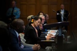 Myanmar's leader Aung San Suu Kyi, center, and Gambia's Justice Minister Aboubacarr Tambadou, left, listen to judges in the court room of the International Court of Justice, in The Hague, Netherlands, Dec. 9, 2019.