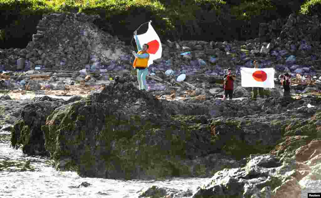 Kelompok nasionalis Jepang menegakkan bendera Matahari Terbit di pulau Uotsuri (19/8).