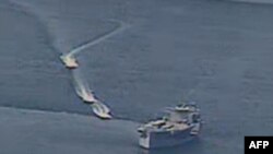 FILE - This photo obtained from the U.S. Navy on April 15, 2020, shows Iranian Islamic Revolutionary Guard Corps Navy vessels conducting what the U.S. said were unsafe actions against U.S. military ships, in international waters of the Persian Gulf.
