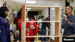 Presiden Obama dan ibu negara, Michelle Obama berpartisipasi dalam "Hari Pelayanan Nasional AS 2013" dengan mengecat sebuah lemari di Sekolah Dasar Burrville, Washington (19/1). 