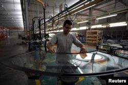 FILE - An employee works inside the Saipa Syria Factory in the industrial city of Hassia in Homs, Syria, Sept. 9, 2018.