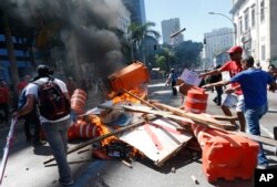 Protesters add to a burning barricade outside the state legislature during a protest against austerity measures being discussed in Rio de Janeiro, Brazil, Dec. 6, 2016. Legislators are voting on measures to address a deepening financial crisis.