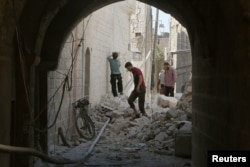 Residents inspect their damaged homes after an airstrike on rebel-held Old Aleppo, Syria, Aug. 15, 2016.