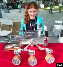Genevieve Beatty, 11, stands in front of the Mars model robot she made with her sister Camille and her father, Robert. (VOA/A. Phillips)