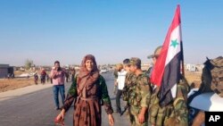 អ្នកស្រុក​ស្វាគមន៍​ទាហាន​ស៊ីរី​ភ្លាមៗ​នៅ​ក្រោយ​ពេល​ពួកគេ​ចូល​ដល់​ក្រុង Tal Tamr កាលពី​ថ្ងៃទី១៤ ខែតុលា ឆ្នាំ២០១៩។