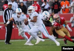 Miami Dolphins quarterback Tua Tagovailoa (1) escapes San Francisco 49ers defensive end Nick Bosa (97) during the first quarter at Levi's Stadium on Dec. 4, 2022. (Kelley L Cox-USA TODAY Sports)
