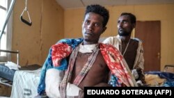 Un civil éthiopian Amlaku Demeke (à gauche) en convalescence avec d'autres survivants du massacre de Mai Kadra le 9 novembre 2020, à l'hôpital universitaire de Gondar dans la région du nord du Tigré en Éthiopie, le 20 novembre 2020. (EDUARDO SOTERAS / AFP)