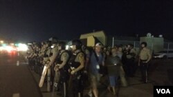 ប៉ូលិស​មើល​បាតុករ​ដែល​ប្រមូល​ផ្តុំ​គ្នា​នៅ​ក្នុង​ទីក្រុង Ferguson រដ្ឋ Missouri កាលពី​ថ្ងៃទី១០ សីហា ២០១៦។