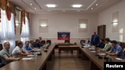 FILE - Representatives of pro-Russia separatists, Kyiv, Moscow and the OSCE are seen at initial talks in Ukraine's eastern city of Donetsk June 23, 2014.