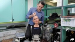 FILE - David Hanson, founder of Hanson Robotics, works on his company's flagship robot Sophia, in Hong Kong, Sept. 28, 2017. Sophia is a creation of the Hong Kong-based startup working on bringing humanoid robots to the marketplace.