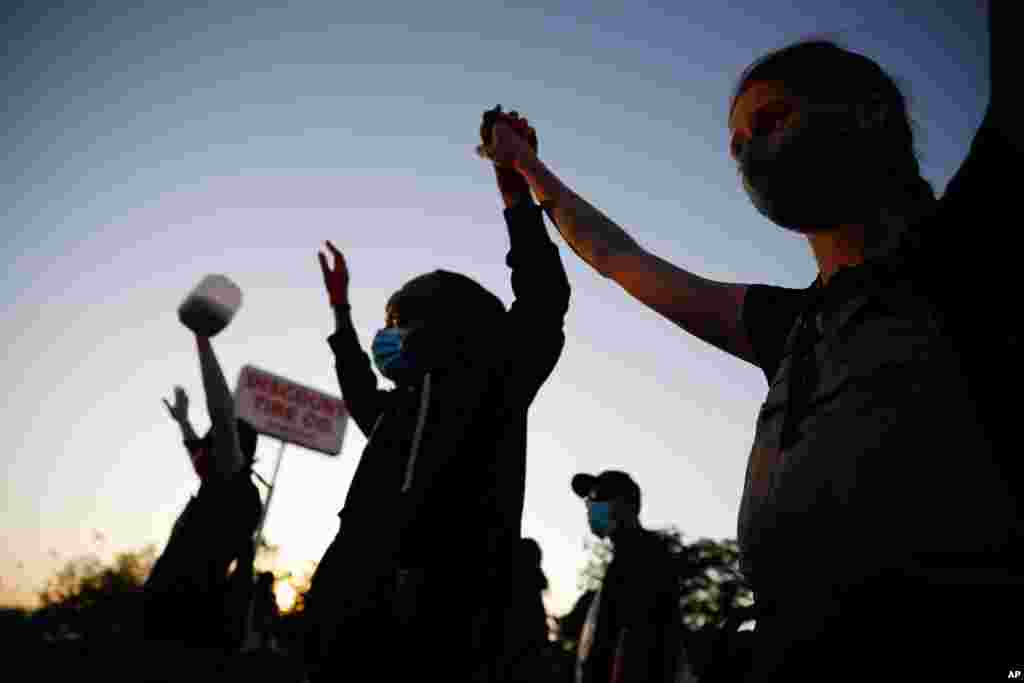 Demonstrators join hands Thursday, May 28, 2020, in St. Paul, Minn. P