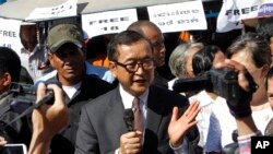 FILE PHOTO - Opposition leader of Cambodia National Rescue Party Sam Rainsy, center, delivers a speech during a gathering to mark Human Rights Day, in front of National Assembly, in Phnom Penh, Cambodia, Wednesday, Dec. 10, 2014. (AP Photo/Heng Sinith)