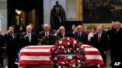 អតីត​រដ្ឋមន្ត្រី​ការបរទេស​លោក Colin Powell (រូប​ទី៣​រាប់​ពី​ឆ្វេង) ដឹកនាំ​អតីត​មេបញ្ជាការ Operation Desert Storm គោរព​វិញ្ញាណក្ខន្ធ​លោក​អតីត​ប្រធានាធិបតី George H.W. Bush កាលពី​ថ្ងៃទី៤ ខែធ្នូ ឆ្នាំ២០១៨។