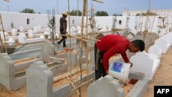 Des ouvriers construisent des tombes au "Jardin d'Afrique", un cimetière du sud tunisien pour les migrants qui se sont noyés en traversant la Méditerranée dans l'espoir d'une vie meilleure en Europe, le 1er juin 2021 dans la ville portuaire de Zarzis, prè