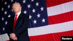 FILE - President Donald Trump stands in front of a U.S. flag.