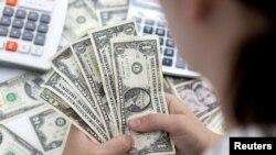 A woman holds U.S. dollar banknotes in this illustration taken on May 30, 2022. (Dado Ruvic/Reuters)