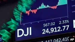 A board above on the trading floor of the New York Stock Exchange shows the closing number for the Dow Jones industrial average, Feb. 6, 2018.
