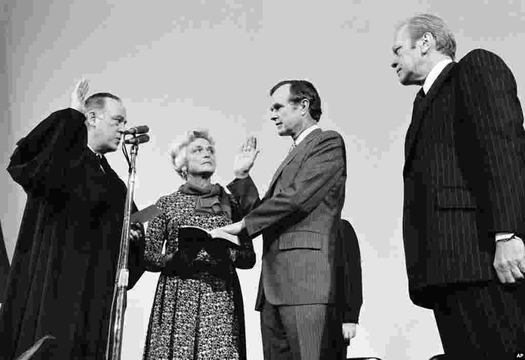 George Bush diambil sumpahnya sebagai direktur baru CIA oleh Hakim Mahkamah Agung Potter Stewart (kiri) selagi istrinya dan Presiden Gerald Ford menyaksikan di markas besar CIA di Langley, Virginia, 30 Januari 1976.