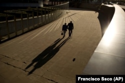 In this Thursday, Sept. 27, 2018 file photo, an elderly couple walks past the Berlaymont building, the European Commission headquarters, in Brussels. Research released on Sunday, July 14, 2019 suggests that a healthy lifestyle can cut the risk of developi