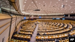 Members of the European Parliament discuss the decision adopted on a strategic framework for the Suasana sidang parlemen Uni Eropa di Brussels. (AP/Geert Vanden Wijngaert)
