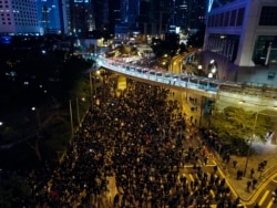In this Sunday, Dec. 8, 2019, photo, pro-democracy protesters march into the night in central Hong Kong. Hundreds of thousands thronged Hong Kong streets.