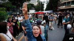Pro-democracy demonstrators flash a three-finger salute of defiance during a protest rally in the Silom business district of Bangkok, Thailand, Oct. 29, 2020. 