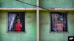 인도 정부가 신종 코로나바이러스 확산을 막기 위해 전국 봉쇄령을 내린 가운데, 25일 가우하티 주민들이 창 밖으로 거리를 내다보고 있다.