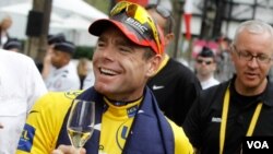 Juara Tour de France Cadel Evans dari Australia diberi minuman anggur di Champs Elysees dalam parade kemenangan di Paris, Minggu (24/7).