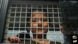 Ethnic Uighur Muslim boy stands inside a police van in Khlong Hoi Khong of southern Songkhla province, Thailand, March 15, 2014. 
