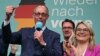 Pemimpin oposisi yang berhaluan konservatif dan Ketua Partai Uni Demokrat Kristen (CDU), Friedrich Merz (kiri) menyapa para pendukungnya setelah hasil exit poll pertama di Berlin, Jerman Minggu (23/2). 