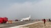 A passenger records the scene as firefighters work after Myanmar National Airlines flight UB103 landed without a front wheel at Mandalay International Airport in Tada-U, Myanmar, May 12, 2019, in this image taken from social media video.
