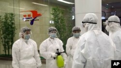 State Commission of Quality Management staff in protective gear and disinfectant prepare to check the health of travelers arriving from abroad at the Pyongyang Airport in Pyongyang, North Korea, Feb., 1, 2020.