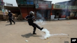 A policeman kicks away a tear gas shell that misfired while trying to disperse activists of Bangladesh Islamist group Hefazat-e-Islam, enforcing a daylong general strike in Narayanganj, March 28, 2021. 