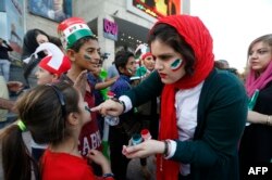 Iranians get ready to watch the World Cup Group B soccer match between Morocco and Iran at Azadi cinema in Tehran, June 15, 2018.