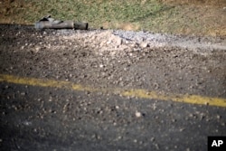 The remains and damage of a rocket fired by Palestinian militants from inside Gaza Strip are left behind after it hit on a main road in southern Israel, July 10, 2014.