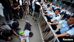 ក្រុម​ប៉ូលិស​ព្យាយាម​យក​បាតុករ​ម្នាក់​ចេញ​ពី​មុខ​ច្រក​ចូល​នៅ​ការិយាល័យ​នាយកប្រតិបត្តិ​ក្រុង​ហុងកុង លោក Leung Chun-ying និង​អគារ​រដ្ឋាភិបាល​ផ្សេង​ទៀត​កាល​ពី​ថ្ងៃ​ទី​២ ​ខែ​តុលា ឆ្នាំ​២០១៤។