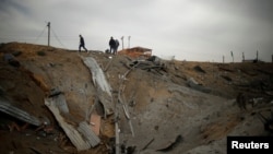 Palestinians inspect the scene of what Gaza police said was an Israeli air strike in the northern Gaza Strip, March 18, 2017. 