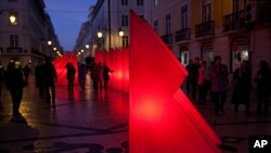 Pedestrians walk around Christmas decorations in on the Rua Augusta, Lisbon's main shopping street, December 5, 2011
