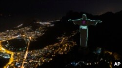FILE - The Portuguese word 'Hunger' is projected over the Rio's Christ the Redeemer statue amid the new coronavirus outbreak in Rio de Janeiro, Brazil, May 10, 2020.