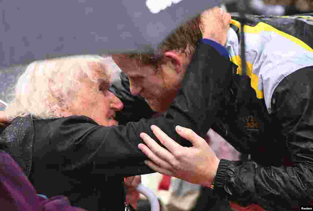 Britain&#39;s Prince Harry hugs Daphne Dunne, 97, during a walk around The Rocks district in rainy Sydney, Australia, during his promotion of the 2018 Invictus Games.