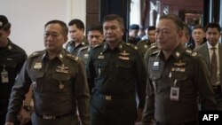 Thai Army Lieutenant General Manas Kongpan, center, is surrounded by police officers as he turns himself in at the police headquarters in Bangkok, June 3, 2015. 