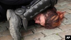 FILE - In this May 26, 2019, file photo, police detain a woman during a yellow vest protest with other groups in Brussels. The death of George Floyd has renewed scrutiny of immobilization techniques long used in policing around the world. (AP Photo/Francisco Seco)