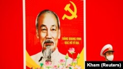 河内的越南国家会议中心外，一名戴口罩的越南士兵正在胡志明肖像前站岗。（2021年1月28日）