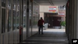 FILE - A man speaks on his phone outside an unemployment office in Madrid, Spain, April 27, 2020.